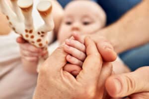 Family of three with young baby stacking hands